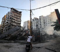 Un hombre fotografía un edificio derrumbado en un suburbio de Beirut. (Fuente: AFP) (Fuente: AFP) (Fuente: AFP)