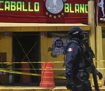 Un policía antimotines custodia el bar después de la masacre. (Fuente: AFP) (Fuente: AFP) (Fuente: AFP)