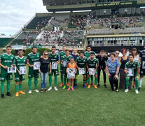 El plantel de Ferro posa con las fotos de los socios desaparacidos. (Fuente: Prensa Ferro) (Fuente: Prensa Ferro) (Fuente: Prensa Ferro)