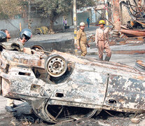 Bomberos apagan un auto incendiado en nueva Delhi en medio de los enfrentamientos. (Fuente: AFP) (Fuente: AFP) (Fuente: AFP)