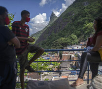 Un grupo  de jóvenes convrsa en un balcón en la favela de Santa Marta, Río de Janeiro. (Fuente: AFP) (Fuente: AFP) (Fuente: AFP)