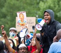  John Boyega arengando a la multitud megáfono en mano. 