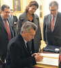Mauricio Macri junto a Juliana Awada y Ramón Puerta al firmar el libro de huéspedes del Palacio de El Pardo. (Fuente: DyN)