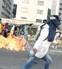 Un manifestante se prepara para lanzar una bomba Molotov en Caracas en un día de marchas a favor y en contra del gobierno. (Fuente: AFP)