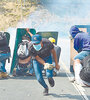 Activistas opositores se escudan en carteles viales arrancados. (Fuente: AFP)