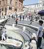 Los turistas se refrescan en la fuente Barcaccia, en la plaza España, en una Roma de calor agobiante. (Fuente: EFE)