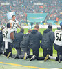 Deportistas de la NFL se arrodillan en el campo de juego durante la entonación del himno.