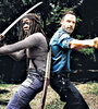 Michonne y el sheriff Rick Grimes, espalda contra espalda para combatir a Negan y su bate con púas.