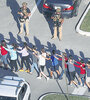 Un grupo de estudiantes evacúa la escuela secundaria de Parkland después de la masacre perpetrada por un ex alumno.