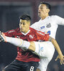 Meza disputa la pelota con el brasileño Pituca. El Rojo apenas empató 0-0 con Santos.