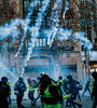 Chalecos amarillos resisten el gas lacrimógeno en los Champs-Elysées. (Fuente: AFP)