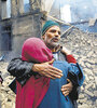 Abrazo frente a un edificio destruido por el fuego cruzado en la Cachemira india. (Fuente: EFE)