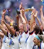 Megan Rapinoe con la Copa del Mundo y el resto del equipo celebrando el bicampeonato. (Fuente: AFP)