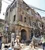 Un grupo de personas camina delante de edificios dañados por las explosiones en el barrio Achrafyeh Rmeil de Beirut. (Fuente: EFE)