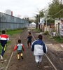 Rodeadas por la Policía Federal y Gendarmería: así están las personas que el 23 de agosto tomaron un terreno de Trenes Argentinos, cerca de la estación Victoria del Ferrocarril Mitre. (Fuente: Leandro Teysseire)