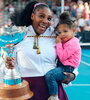 Serena Williams con un trofeo en un brazo y su hija Olympia en el otro. (Fuente: AFP)