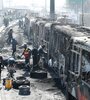 Funcionarios y peritos trabajan con los restos de buses de TransMilenio incinerados durante las protestas.  (Fuente: EFE)