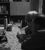 Una pareja mayor contempla con ternura una pantalla apoyada en la mesa del comedor. Del taller de fotografía de La Vigil. (Fuente: Gabriel Terrera)