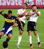 Tevez y Ponzio disputan la pelota en el último Superclásico, 2-2 en La Bombonera. (Fuente: AFP)