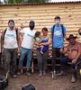 Vecinos y voluntarios de la ong Techo  junto a una vivienda construida.