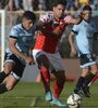 Mas intenta ganar la posición ante jugador de Belgrano (Fuente: Télam)