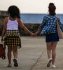 Dos mujeres caminan tomadas de la mano en el Malecón de La Habana (Fuente: AFP)