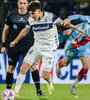 Domínguez se lleva la pelota ante Pittón; ganó el Lobo y llegó a la punta (Fuente: Fotobaires)