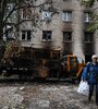 Dos mujeres caminan frente a una casa bombardeada en Balakliya, región de Kharkiv. (Fuente: AFP)