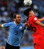 Diego Godín lucha por la pelota con un jugador coreano (Fuente: Télam)