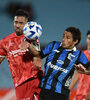 Avalos intenta cabecear ante la marca de Meli (Fuente: AFP)