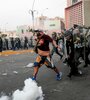 Un manifestante enfrenta a policías durante una protesta en el centro de Lima.  (Fuente: Xinhua) (Fuente: Xinhua)