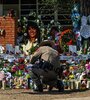 Un oficial de policía limpia el memorial improvisado en la escuela primaria Robb en Uvalde, Texas. (Fuente: AFP)