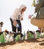 Nora Cortiñas regando simbólicamente el  proyecto "Por Cada Mina Una Flor", del artista saharaui Moulud Yeslem, en las próximidades del Muro de la Vergüenza.  (Fuente: Carlos Cazurro)