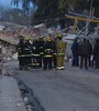 Bomberos y peritos frente a los escombros del edificio derrumbado.