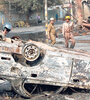 Bomberos apagan un auto incendiado en nueva Delhi en medio de los enfrentamientos. (Fuente: AFP)