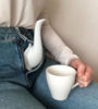 Refinamiento fálico, tetera y taza de té en mano en plan surrealista. 