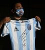 Diego Maradona y la camiseta firmada que donó para juntar fondos. (Fuente: Twitter)